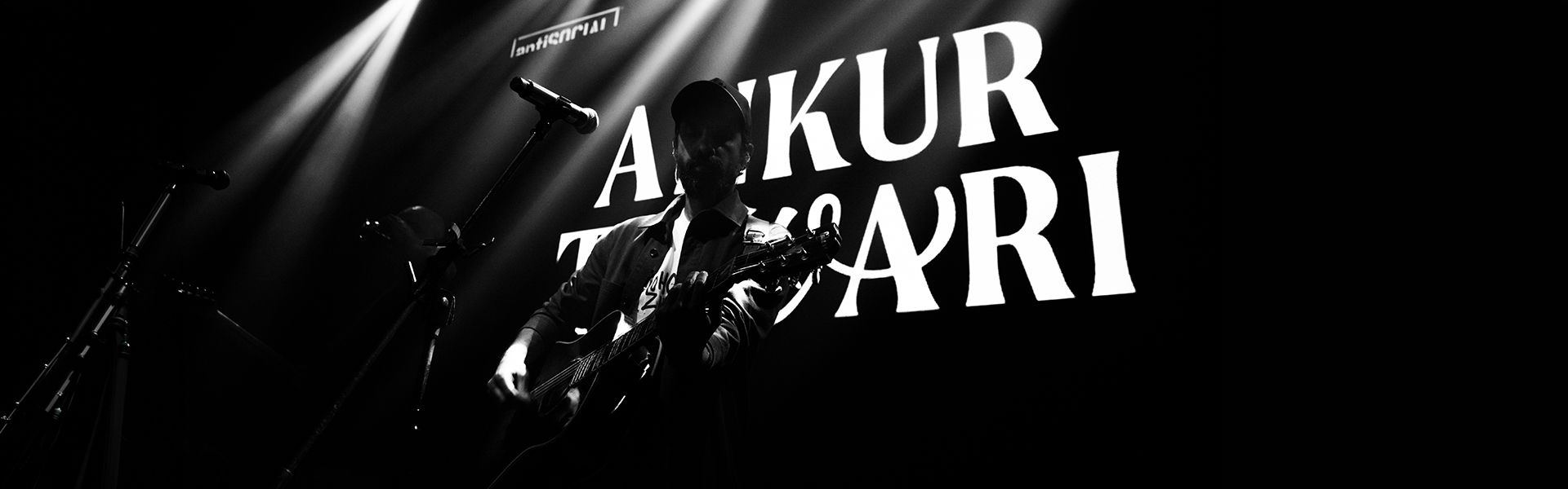 Tiwari performing live at antiSOCIAl Mumbai under dramatic stage lighting with his name projected behind him
