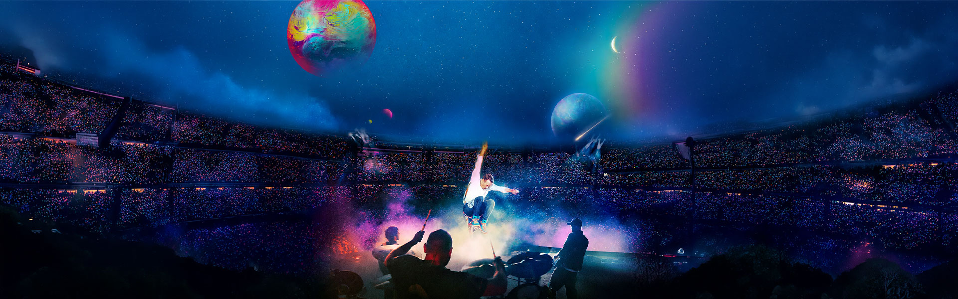 Coldplay performing live on stage during the Music of Spheres world Tour India 2025, with cosmic visuals and a packed stadium crowd