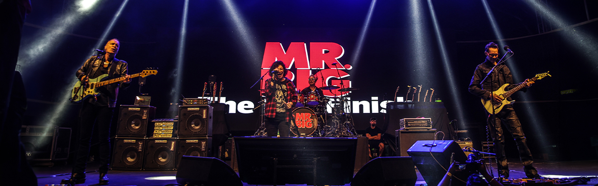 Mr. Big full band performing live on stage during The Big Finish farewell tour India 2025, with MR. BIG logo displayed behind them