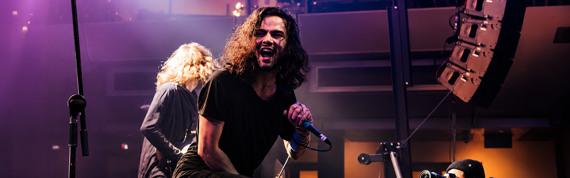 Northlane vocalist Marcus Bridge performing live on stage with intense lighting during the band's India debut tour in July 2025