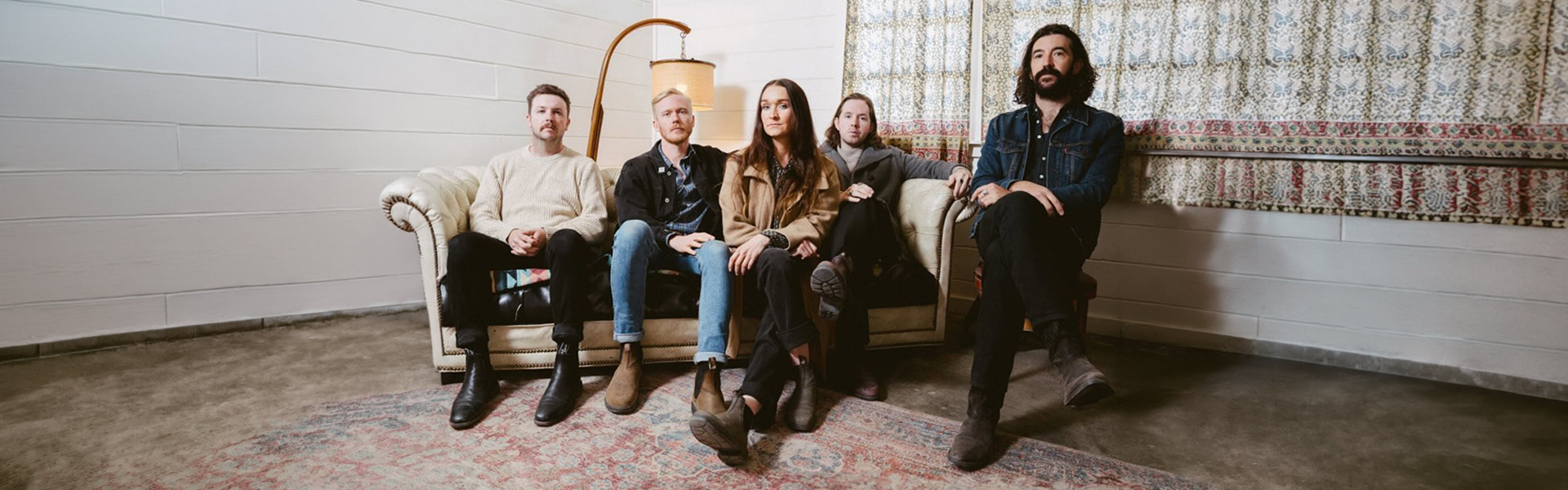 The Paper Kites full band official press photo, five members seated on a vintage couch for India Tour 2025